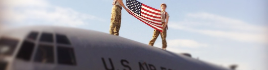 Emily Elmore 1L and Air Force Veteran Emily Elmore (left) holds an American flag on top of an Air Force plane.