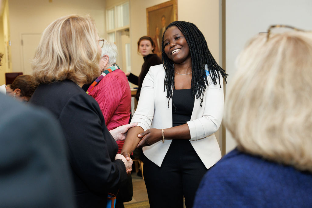 Dr. Jane Anyango shaking hands and socializing before the lecture