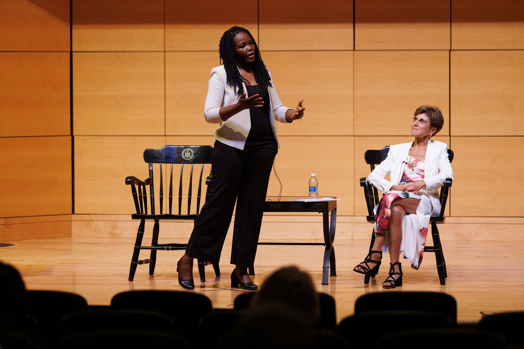 Dr. Jane Anyango on stage standing up with Cathy Lee