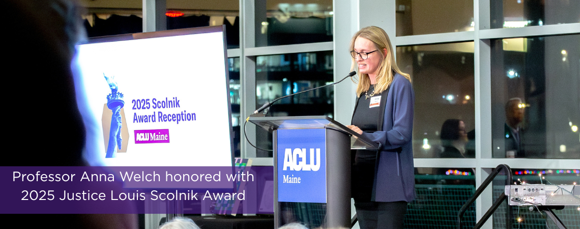 Photo of Anna Welch in front of microphone at ACLU event